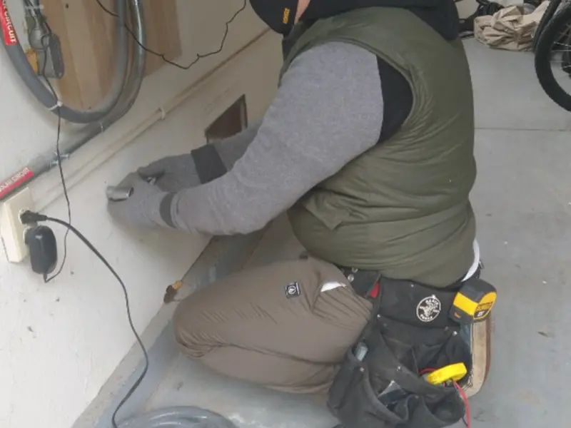 Electrician performing outlet wiring in a Ladue garage